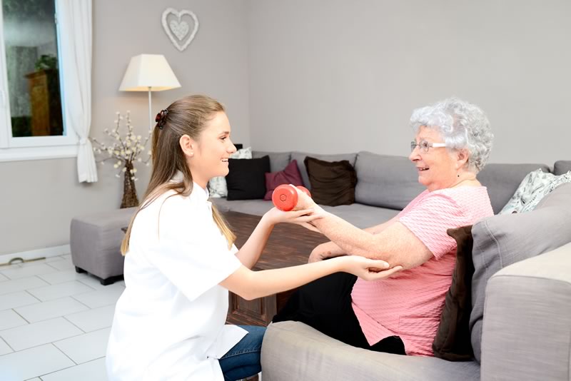 physical therapists helping elderly women